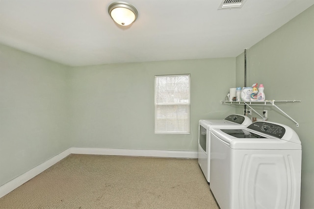 clothes washing area with light colored carpet, laundry area, visible vents, baseboards, and washer and dryer