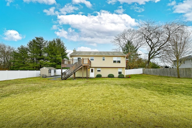 rear view of house featuring a storage unit, a fenced backyard, stairway, and an outbuilding