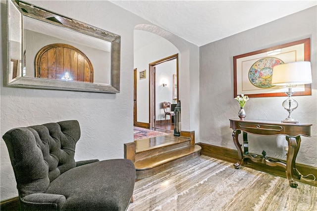 31 Old Army Rd, Scarsdale, NY 10583 - sitting room featuring arched walkways, wood finished floors, a textured wall, and baseboards