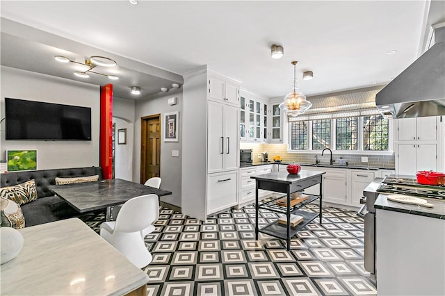 31 Old Army Rd, Scarsdale, NY 10583 - kitchen with white cabinets, ventilation hood, a chandelier, backsplash, and high end range
