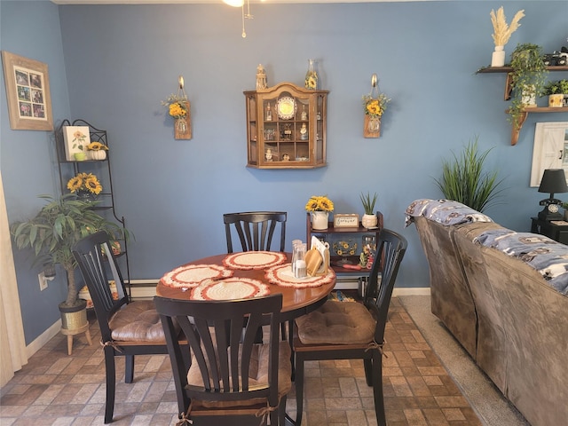 dining area featuring brick floor, a baseboard radiator, and baseboards