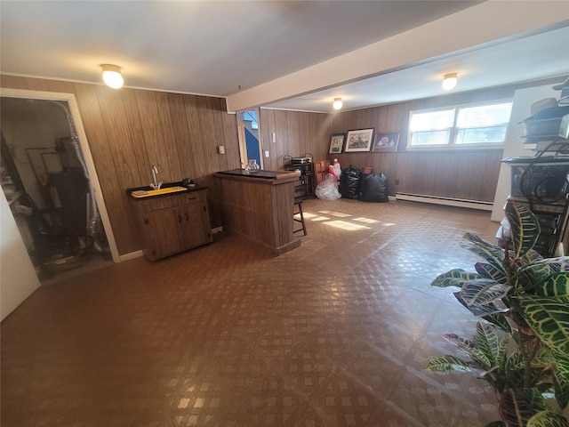 bar with a baseboard heating unit, dark floors, and wood walls