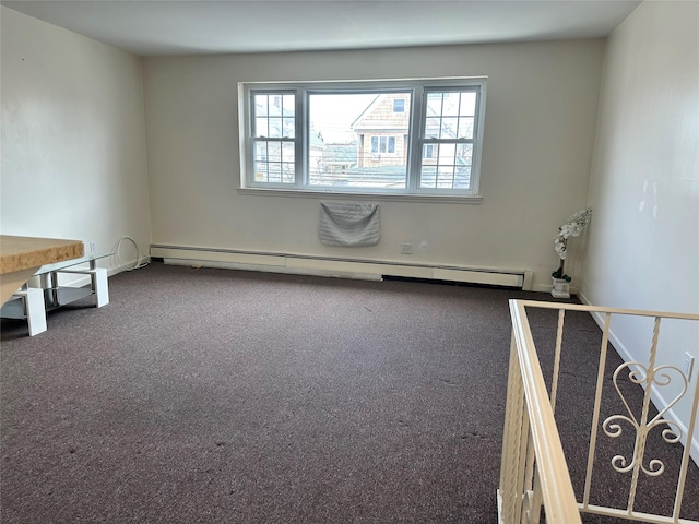 spare room featuring baseboard heating and carpet flooring