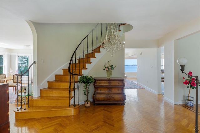 staircase with arched walkways and baseboards