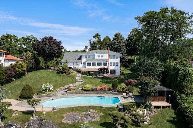 pool featuring a lawn and a wooden deck