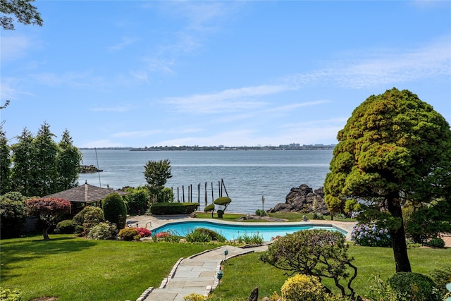 pool with a water view and a lawn