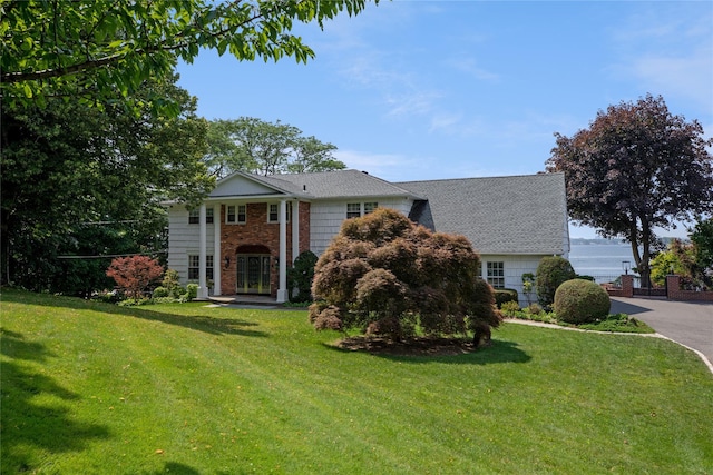 neoclassical / greek revival house featuring a front yard