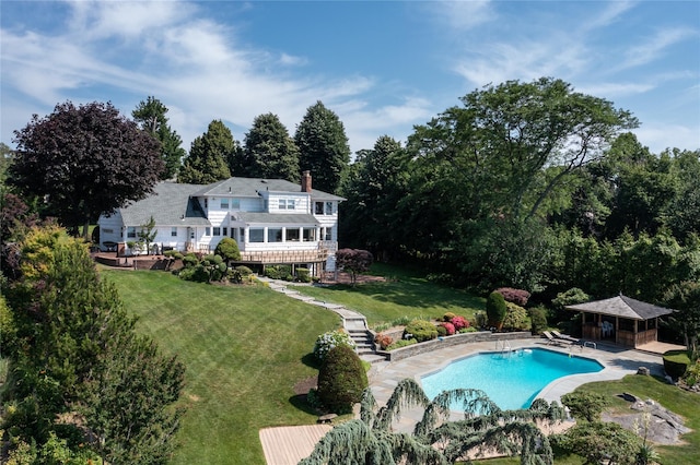 pool featuring a patio area, stairs, an outdoor structure, and a yard