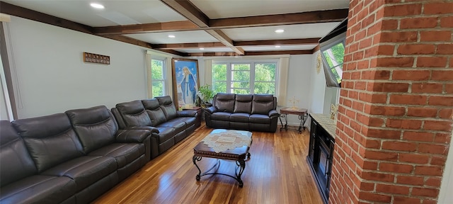 living area featuring beamed ceiling, light wood-style flooring, and baseboards