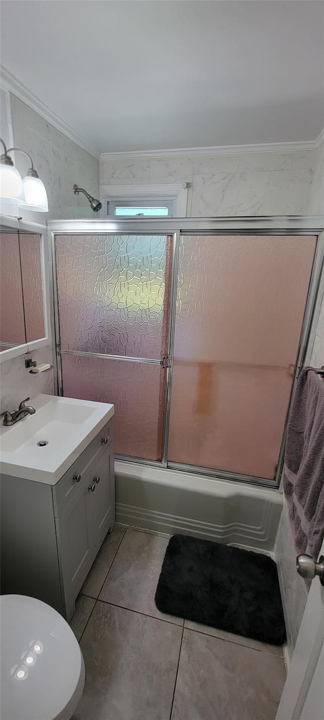 full bathroom featuring toilet, tile patterned flooring, combined bath / shower with glass door, crown molding, and vanity