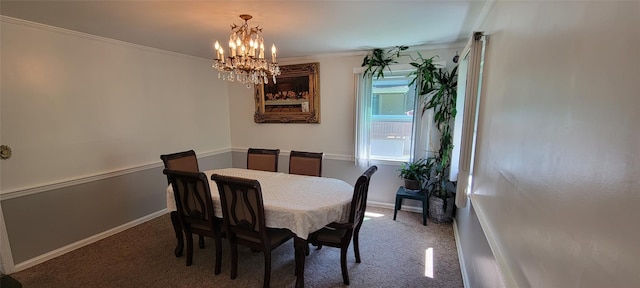 dining space featuring baseboards, a chandelier, carpet flooring, and crown molding