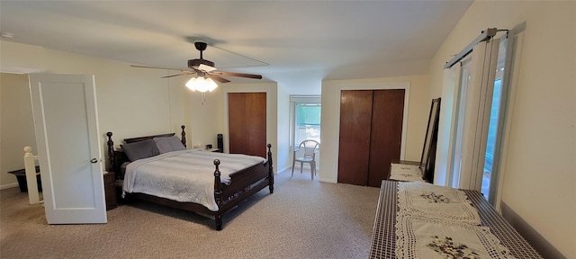 bedroom featuring light carpet, two closets, a ceiling fan, and baseboards