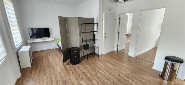 interior space featuring radiator, plenty of natural light, baseboards, and wood finished floors