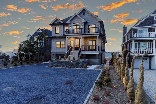 shingle-style home featuring stairs and a balcony