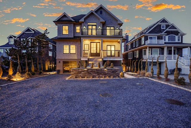 view of front of house featuring a garage, driveway, and a balcony