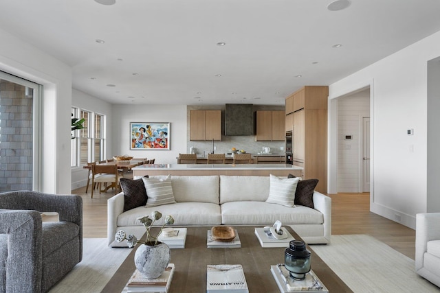 living area with light wood finished floors, baseboards, and recessed lighting