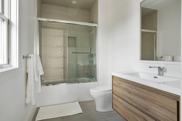 bathroom with shower / bath combination with glass door, vanity, toilet, and tile patterned floors