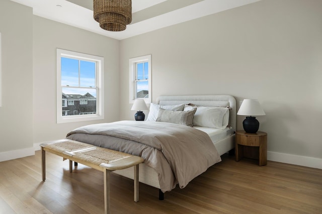 bedroom with baseboards and wood finished floors