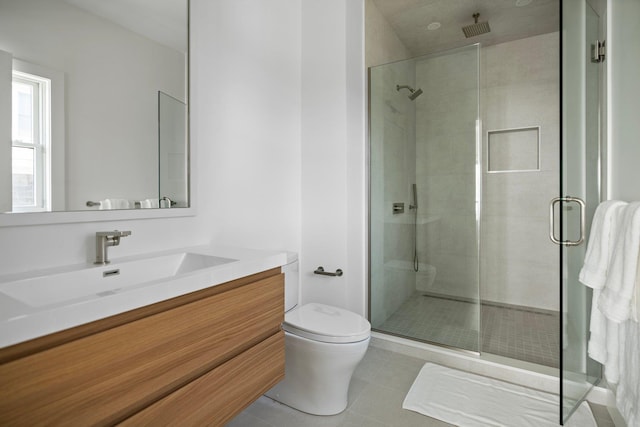 bathroom with a stall shower, vanity, toilet, and tile patterned floors