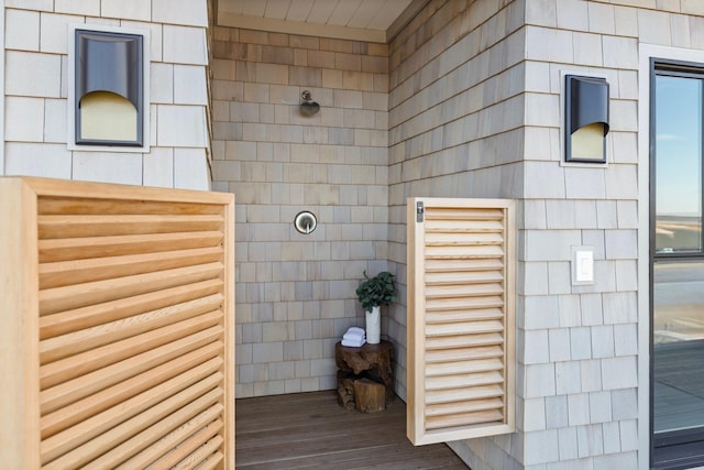 full bathroom with a walk in shower, wood finished floors, and tile walls