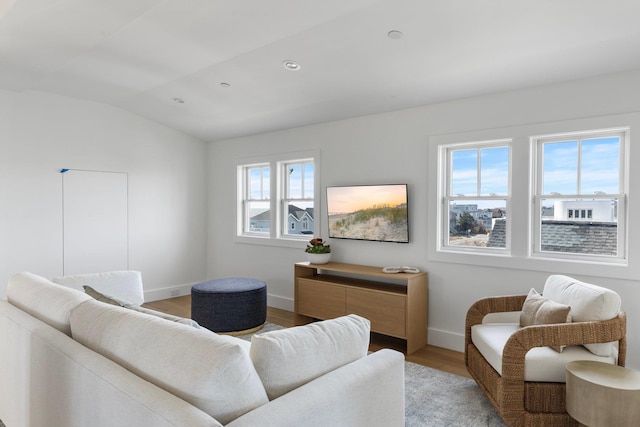 living room featuring lofted ceiling, light wood-style flooring, baseboards, and recessed lighting