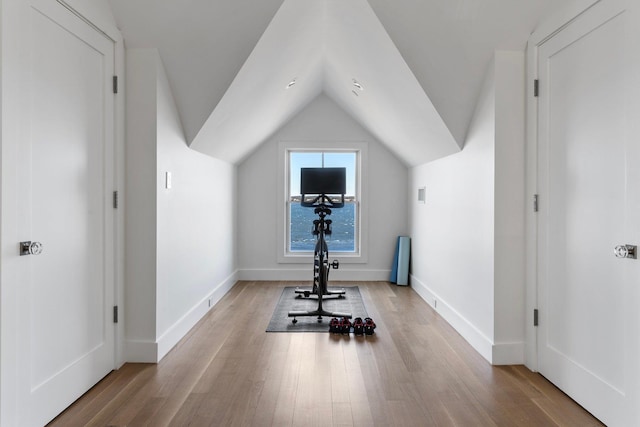 workout area with lofted ceiling, baseboards, and wood finished floors