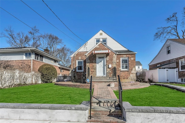 view of front facade featuring brick siding, a front lawn, and fence