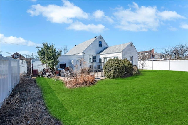 back of house featuring a yard and a fenced backyard