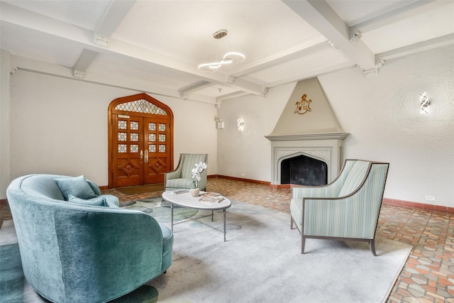 living area featuring arched walkways, a fireplace, beam ceiling, and baseboards