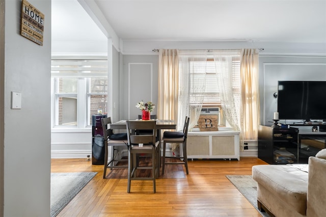 dining area featuring radiator, wood-type flooring, and baseboards