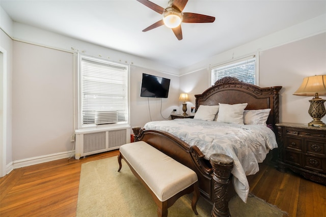 bedroom featuring radiator, ceiling fan, baseboards, and wood finished floors