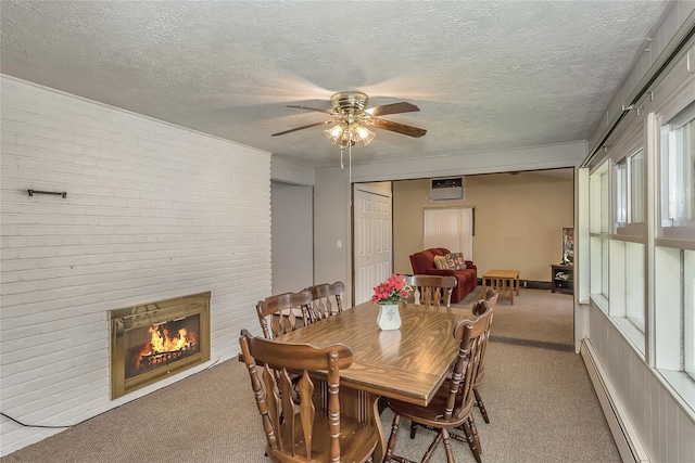 carpeted dining space with a brick fireplace, a ceiling fan, baseboard heating, and a textured ceiling