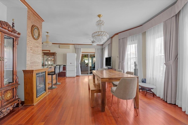 dining space with ornamental molding, hardwood / wood-style floors, and a fireplace