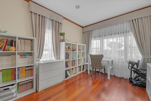 sitting room with a wealth of natural light, crown molding, and wood finished floors