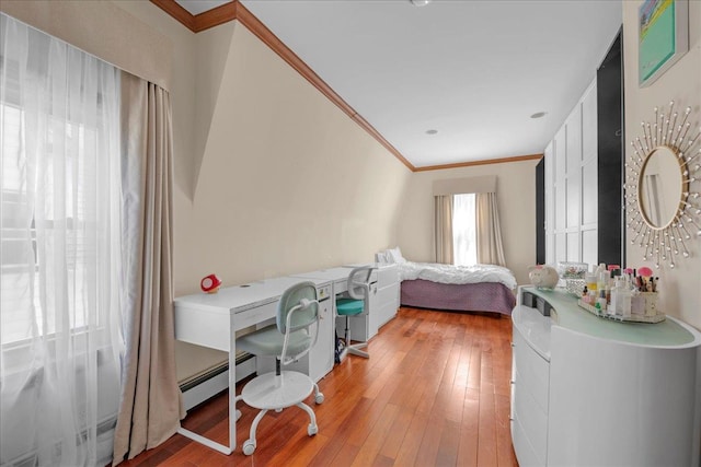 bedroom with a baseboard radiator, crown molding, and light wood-style flooring