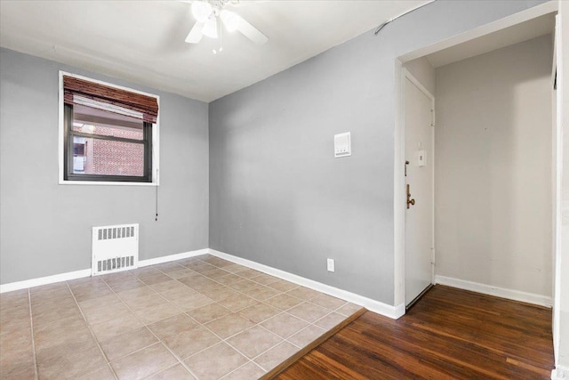 spare room featuring wood finished floors, visible vents, baseboards, and ceiling fan