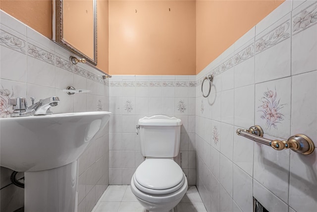 bathroom with toilet, tile walls, and tile patterned floors