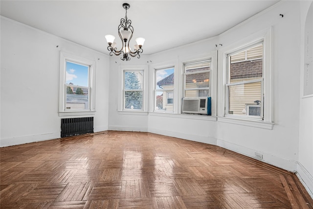 empty room with cooling unit, baseboards, radiator heating unit, an inviting chandelier, and crown molding