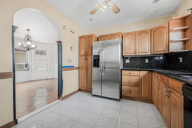 kitchen with arched walkways, stainless steel fridge with ice dispenser, open shelves, backsplash, and ceiling fan with notable chandelier