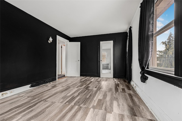 empty room with plenty of natural light and wood finished floors