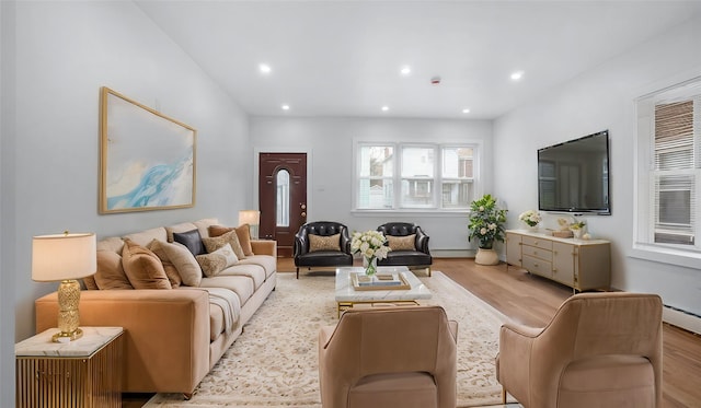 living room featuring a baseboard radiator, light wood-style flooring, and recessed lighting