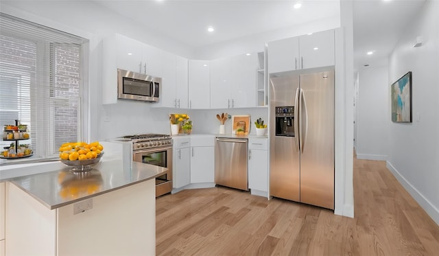 kitchen with stainless steel appliances, recessed lighting, white cabinets, modern cabinets, and light wood-type flooring