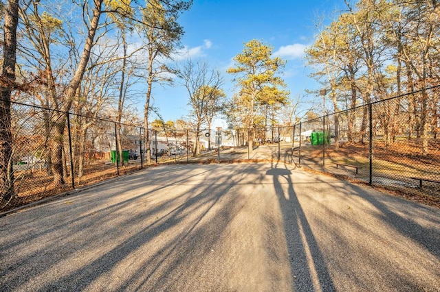 view of home's community with community basketball court and fence