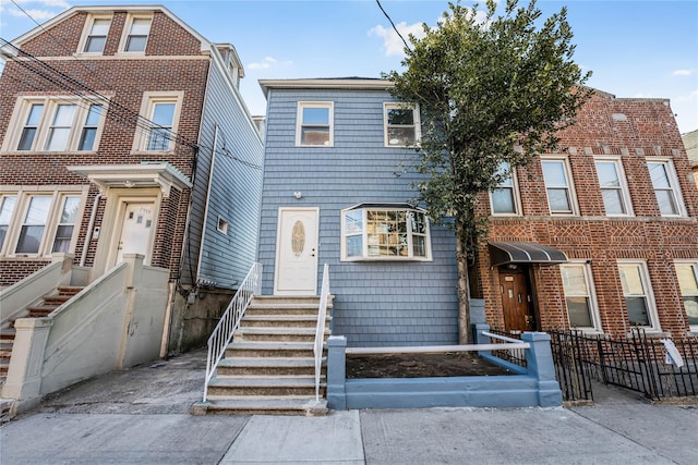 townhome / multi-family property featuring entry steps and a fenced front yard