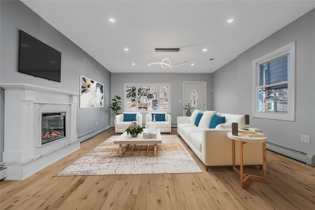 living area featuring a baseboard radiator, a premium fireplace, wood finished floors, and recessed lighting