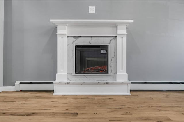 interior details featuring baseboard heating, wood finished floors, and a high end fireplace