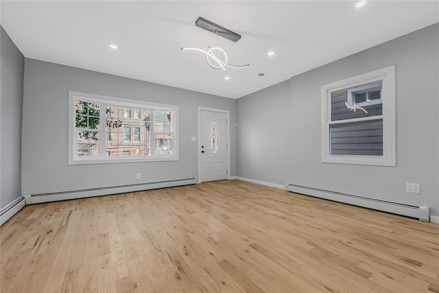 unfurnished room featuring an inviting chandelier, baseboard heating, wood finished floors, and recessed lighting