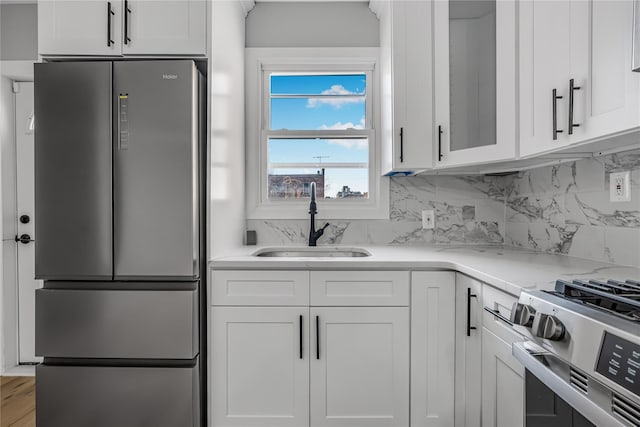 kitchen featuring appliances with stainless steel finishes, white cabinets, and a sink