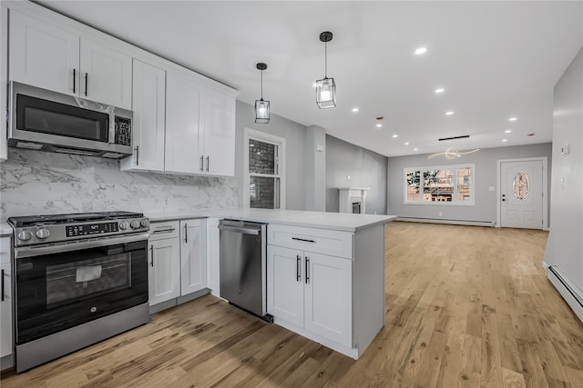 kitchen featuring a peninsula, white cabinetry, light countertops, appliances with stainless steel finishes, and light wood finished floors