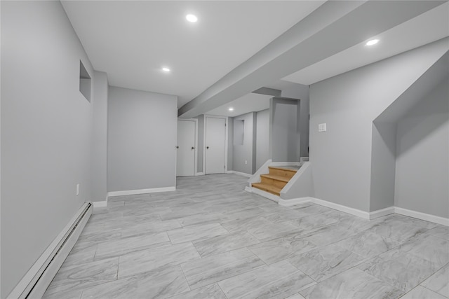 finished basement with a baseboard heating unit, recessed lighting, stairway, and baseboards